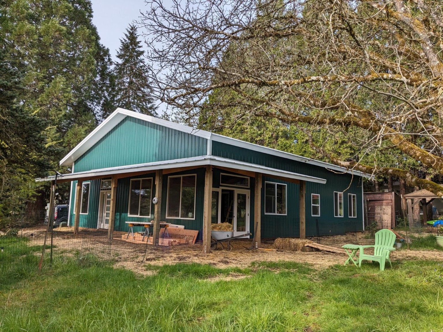 Custom green post-frame barndominium with a covered porch