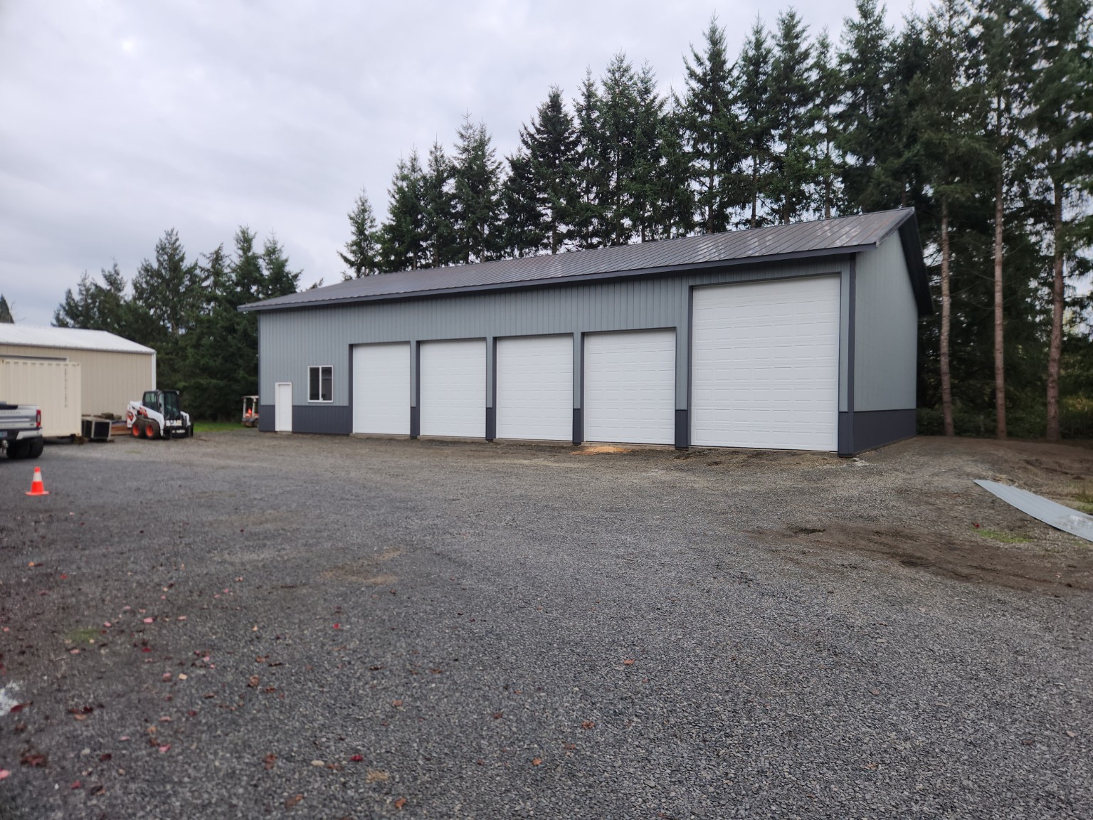 Large gray post-frame garage with multiple overhead doors