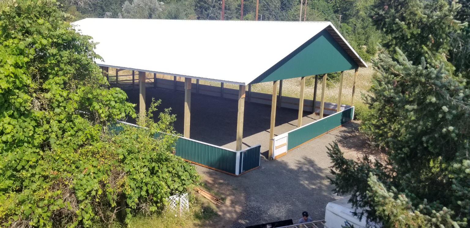 Covered horse arena surrounded by Oregon trees